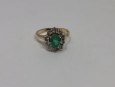 A 14ct yellow gold emerald and diamond cluster ring, the medium green emerald 7.