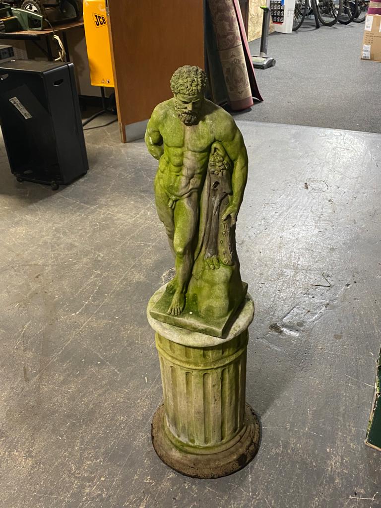 A concrete figure of a Greek god on pedestal