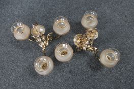 Two brass three way light fittings with glass shades