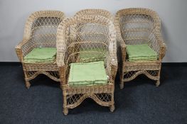 A set of four high backed wicker conservatory armchairs