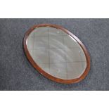 An early 20th century oval framed bevelled mirror
