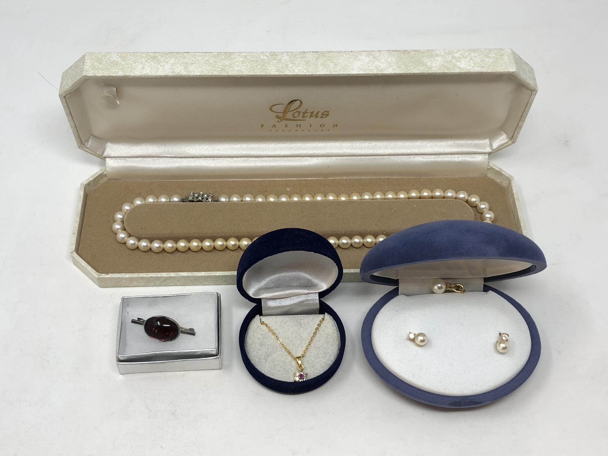 A boxed pearl necklace, simulated pearl pendant and earrings,