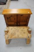 A pine double door cabinet together with a leather seated camel stool