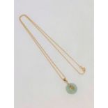 A jade disc pendant on 9ct gold chain CONDITION REPORT: 1.