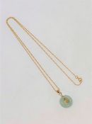 A jade disc pendant on 9ct gold chain CONDITION REPORT: 1.