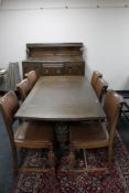 An early 20th century carved eight piece oak dining room suite comprising buffet backed sideboard,