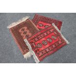 Three fringed woolen Persian hearth rugs on red ground