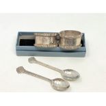 A pair of Lindisfarne silver napkin rings and a boxed pair of spoons depicting St.