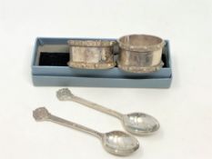 A pair of Lindisfarne silver napkin rings and a boxed pair of spoons depicting St.