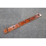 An early 20th century seven hook coat rack