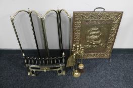 A folding three brass spark guard, four piece companion set on stand,