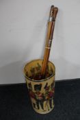 A 20th century stick stand depicting figures in military dress and four swagger sticks one with