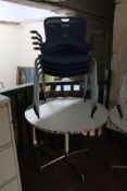 A circular pedestal cafe table and four blue plastic armchairs