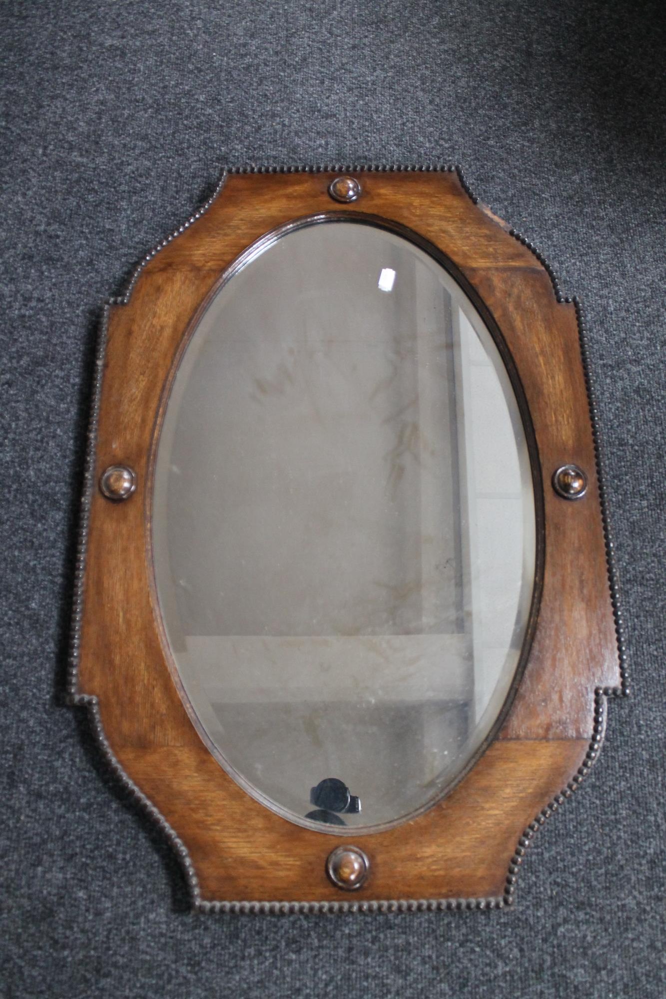 A shaped Edwardian bevelled oak mirror