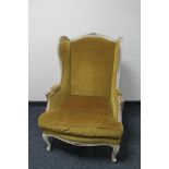 A painted framed French wingback armchair upholstered in dralon fabric