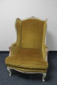 A painted framed French wingback armchair upholstered in dralon fabric