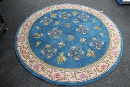 A circular floral Chinese rug on blue ground. CONDITION REPORT: 182cm diameter.