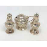 A three piece silver condiment set.