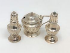 A three piece silver condiment set.