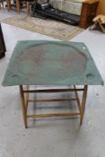 An eastern metal tray on Ercol table base