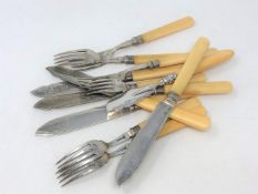 Twelve various pieces of EPNS fish cutlery with silver ferrules.