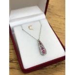 A 10ct white gold ruby and diamond pendant on chain