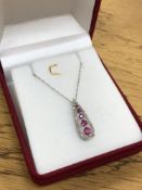 A 10ct white gold ruby and diamond pendant on chain