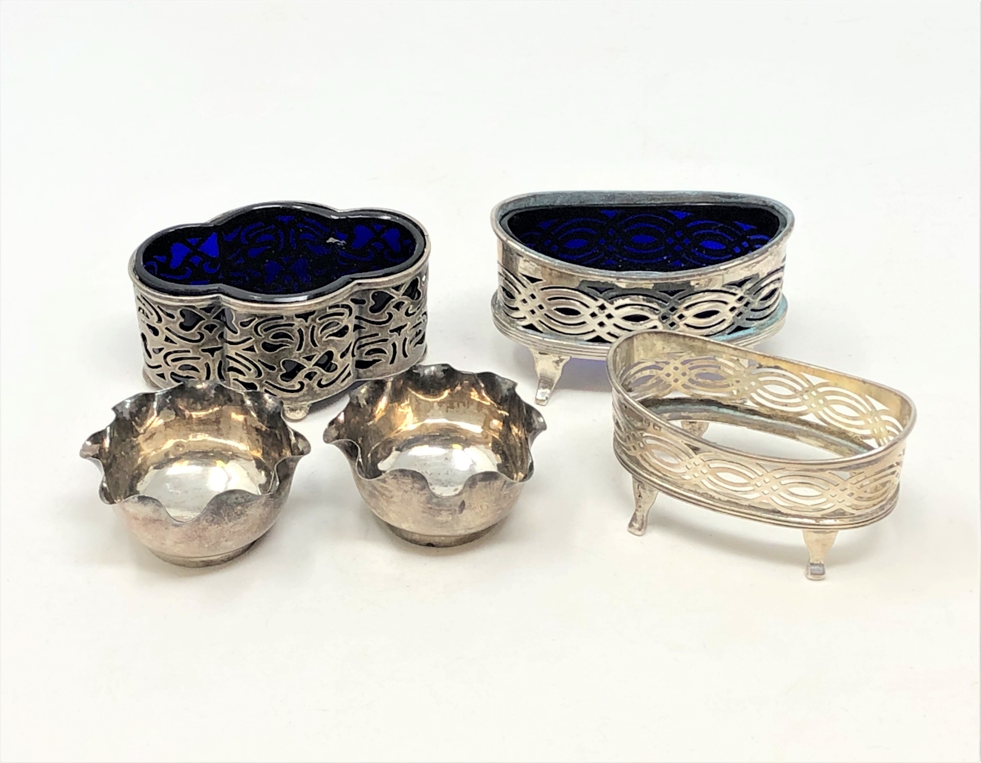 A pair of silver salts, and three other larger examples.