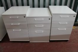 Three white three drawer under-desk filing chests