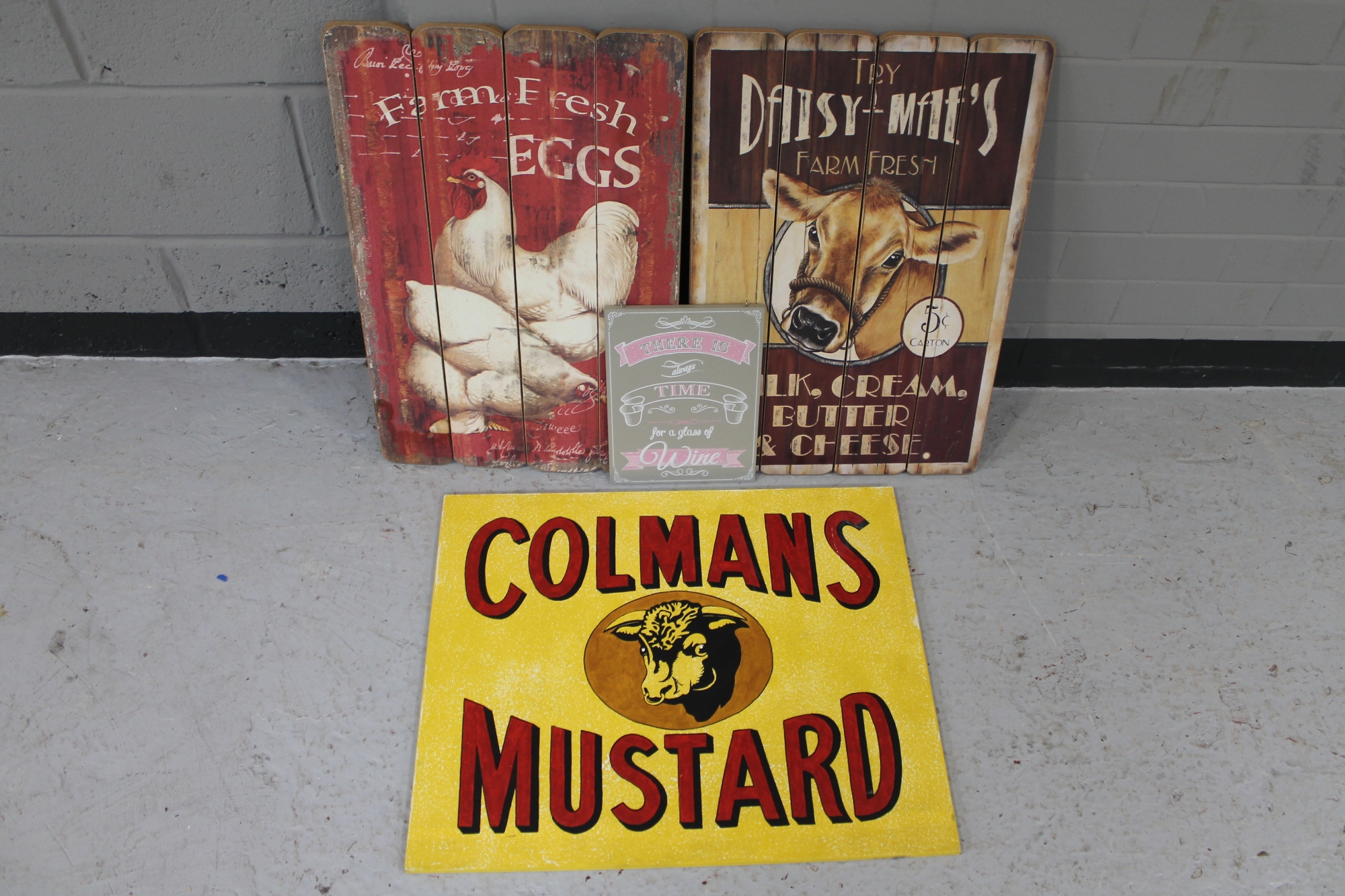 Four wooden signs "Colemans Mustard" "fresh farm eggs" "fresh farm diary" and "time for wine"