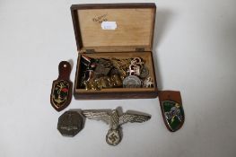 A trinket box containing militaria to include German eagle badge, WWI medal on ribbon,