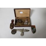 A trinket box containing militaria to include German eagle badge, WWI medal on ribbon,