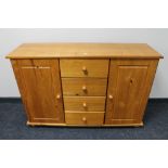 A pine double door sideboard fitted with four central drawers
