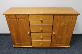 A pine double door sideboard fitted with four central drawers