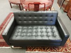 A pair of black leather two seater settees,