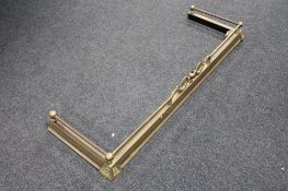 An antique brass fire curb