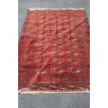 A Bokhara rug, Afghanistan, on red ground CONDITION REPORT: 193cm by 143cm.