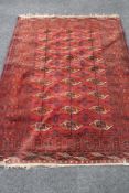 A Bokhara rug, Afghanistan, on red ground CONDITION REPORT: 193cm by 143cm.
