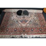 A fringed floral wool rug on peach ground,