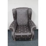 A wingback armchair in grey pheasant print upholstery