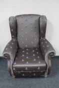 A wingback armchair in grey pheasant print upholstery