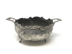 An ornate early 19th century twin handled silver bowl depicting a country scene CONDITION