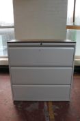 A three drawer metal document cabinet with wood top