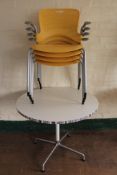 A circular pedestal cafe table and four plastic armchairs