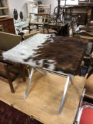 A 20th century cow hide upholstered lamp table on metal X-framed support