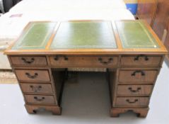 A mahogany twin pedestal writing desk with three green leather inset panels