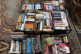 A pallet of seven boxes of paperback books, novels,