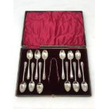A cased harlequin set of twelve Edwardian silver teaspoons and sugar tongs, various marks.