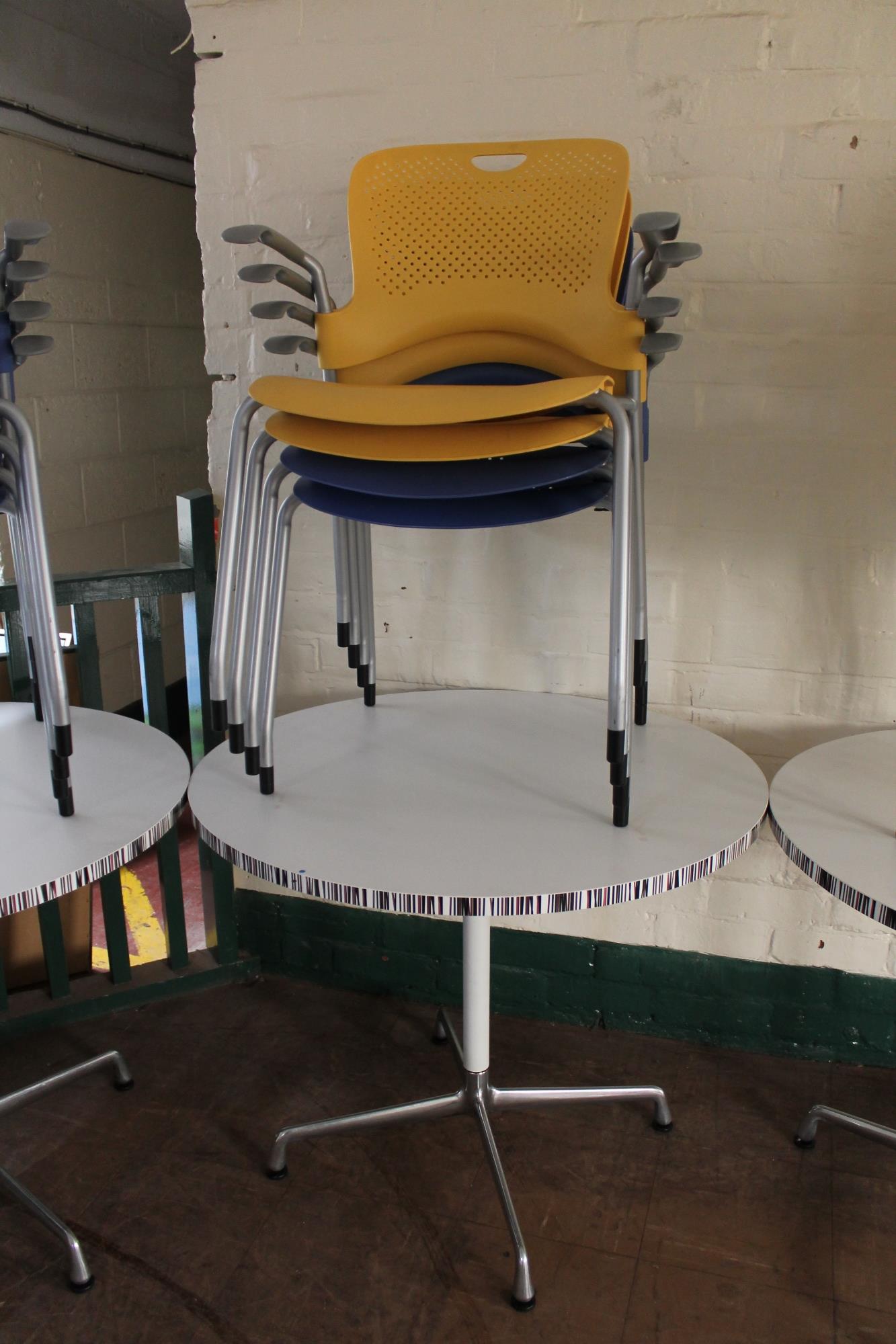 A circular pedestal cafe table and four plastic armchairs