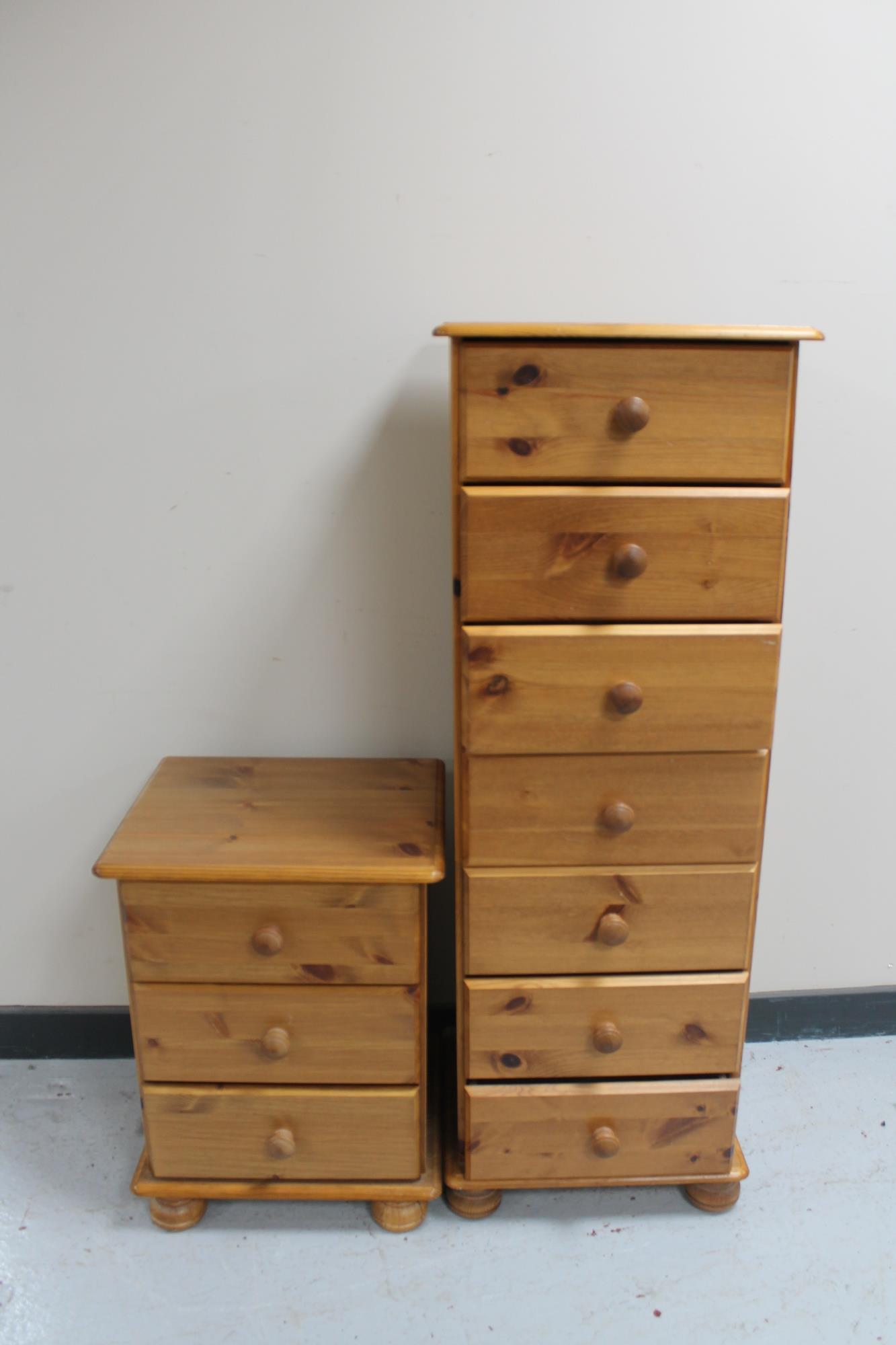 A narrow pine seven drawer chest and a pine bedside chest